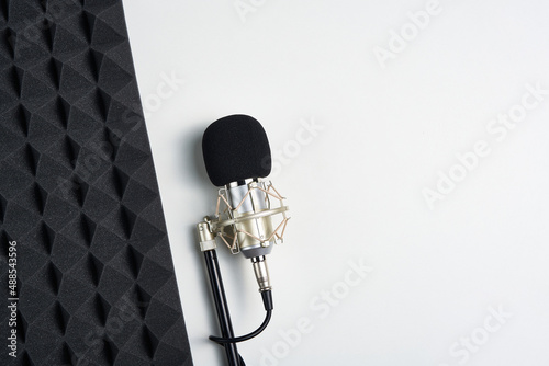 Flat lay of microphone and acoustic foam panel, over white background