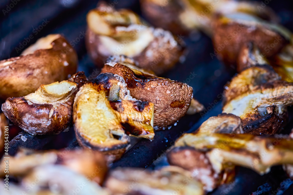 close up with brown champignon mushrooms on the grill. close up with brown champignon mushrooms on the grill.