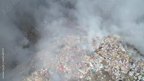 Aerial drone view of large garbage landfill, burning trash with loth of polluting smoke. 