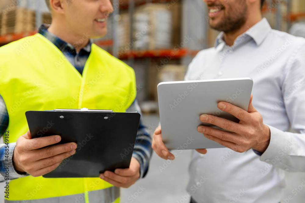 wholesale, logistic business and people concept - close up of warehouse worker and businessman with clipboard and tablet pc computer wholesale, logistic business and people concept - close up of warehouse worker and businessman with clipboard and tablet pc computer