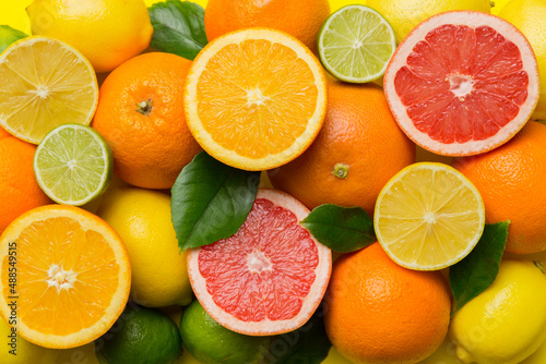 Flat lay of citrus fruits like lime  orange and lemon with lemon tree leaves on light colored background. Space for text healthy concept. Top view