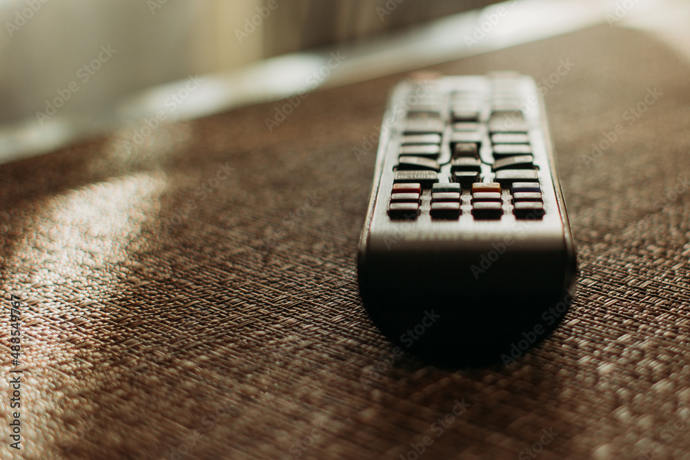 The TV remote is on the table. selective focus The TV remote is on the table. selective focus