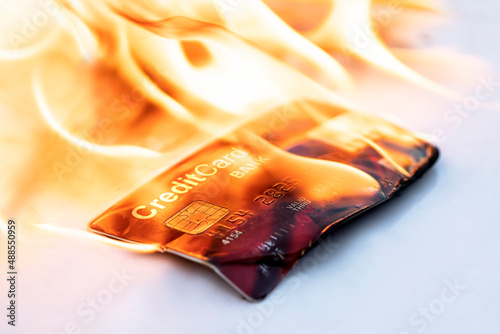 Bank credit card in flames on black background. Concepts of collapse of financial markets and the credit and financial system. Sanctions and disconnection from the swift system. photo