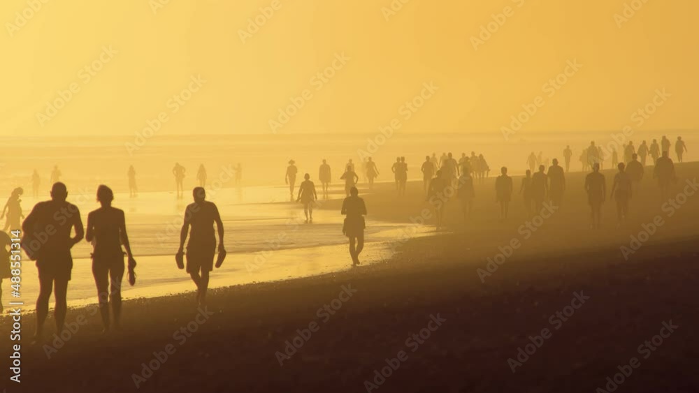 People in contre-jour light at the beach. Maspolomas beach on Canary island. Beach siesta at the Atlantic ocean. Canary island resort. Canary islands, Spain. People in contre-jour light at the beach. Maspolomas beach on Canary island. Beach siesta at the Atlantic ocean. Canary island resort. Canary islands, Spain.