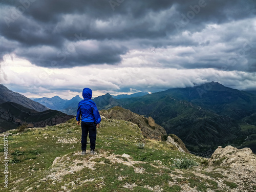 A boy on the background of a breathtaking view of the mountains during a thunderstorm in Dagestan, Caucasus, Russia