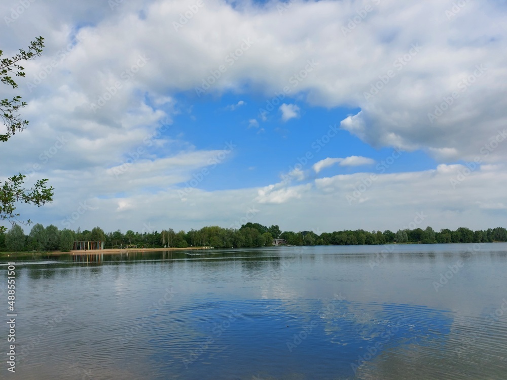 Eine Spiegelung des Himmels im Wasser des Sees. Der Himmel mit Wolken spiegelt sich im Wasser des Ozeans. Das Himmelblau macht das Meer schön blau. Die Wasseroberfläche ist ruhig. Reflexion. 