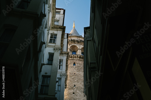 Galata tower, great view of galata tower seen from a narrow street, the unique beauty seen from the narrow street squeezed by the apartments, low angle architectural view, Istanbul,Turkiye,01-30-2022