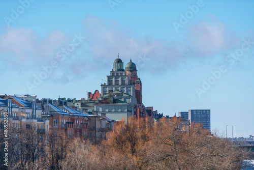 View over the water front buildings at the icy canal Karlbergskanalen, dome and tower buildings a sunny winter day in Stockholm