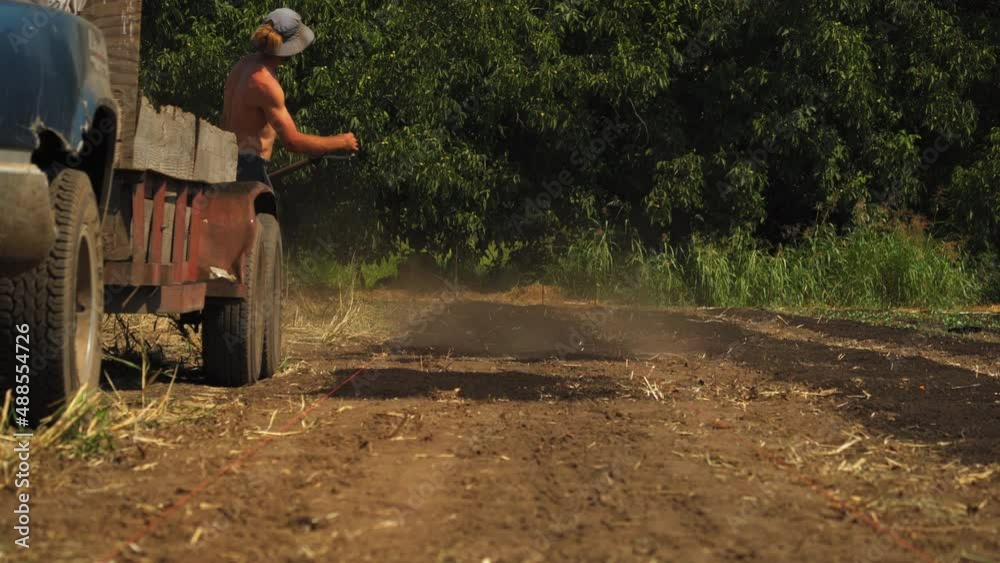 Static view of farmers working hard and tilling the land for getting the soil ready for cucumber harvesting on a hot day. Static view of farmers working hard and tilling the land for getting the soil ready for cucumber harvesting on a hot day.