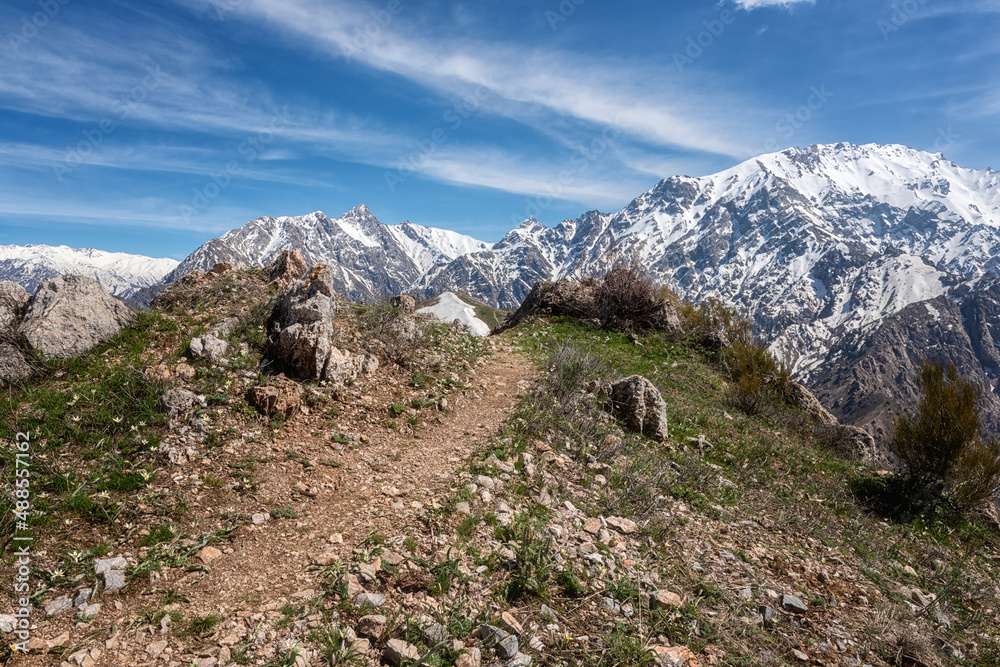 Scenic tourist route on Chimgan mountain range with Greater Chimgan peak view in spring, amazing nature landscape with blue sky, outdoor travel background, Uzbekistan, near the Tashkent