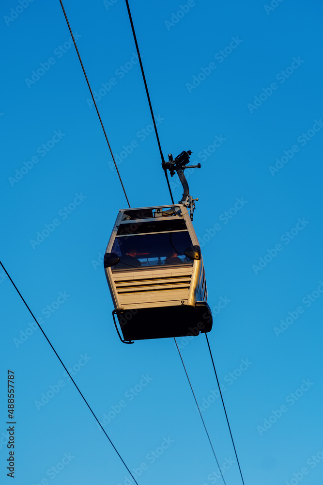 Tourists riding a gondola of the cable car against blue sky