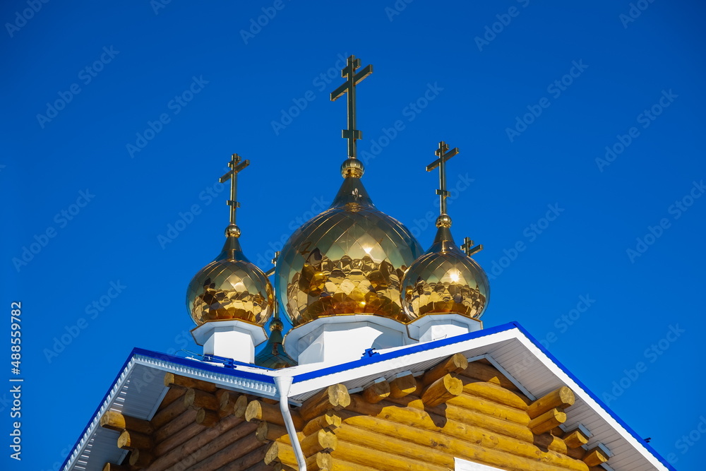 The building of the Orthodox church on the background of blue sky with white clouds in winter. Russia. Ural.