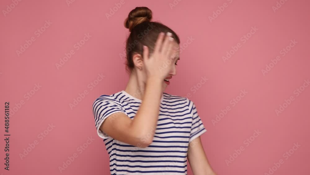 Don't want to look. Portrait of woman keeping hand on eyes, grimacing in disgust and turning away from camera, avoiding watch at something shameful. Indoor studio shot isolated on pink background. Don't want to look. Portrait of woman keeping hand on eyes, grimacing in disgust and turning away from camera, avoiding watch at something shameful. Indoor studio shot isolated on pink background.