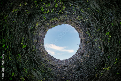 Fotobehang Blick nach oben durch die runde Öffnung eines steinernen Turms
