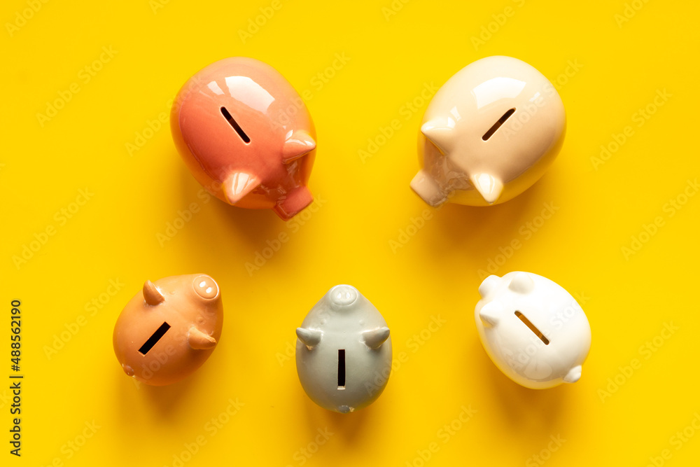 Fototapeta premium Many piggy bank - different types of currency saving and investments
