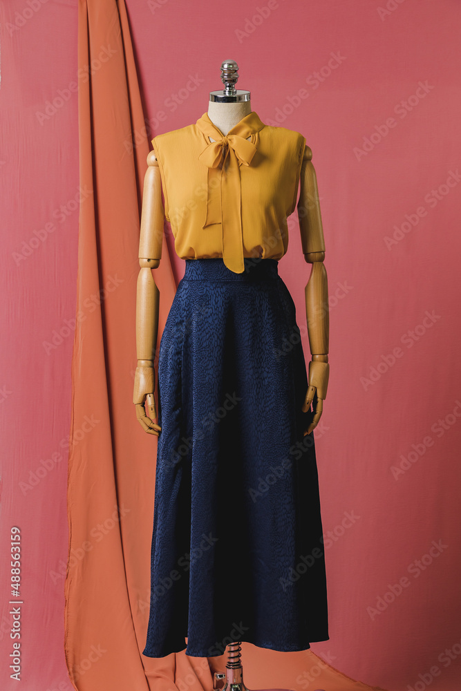 mannequin in a dress on a mannequin red pink background fashion still photography blouse skirt