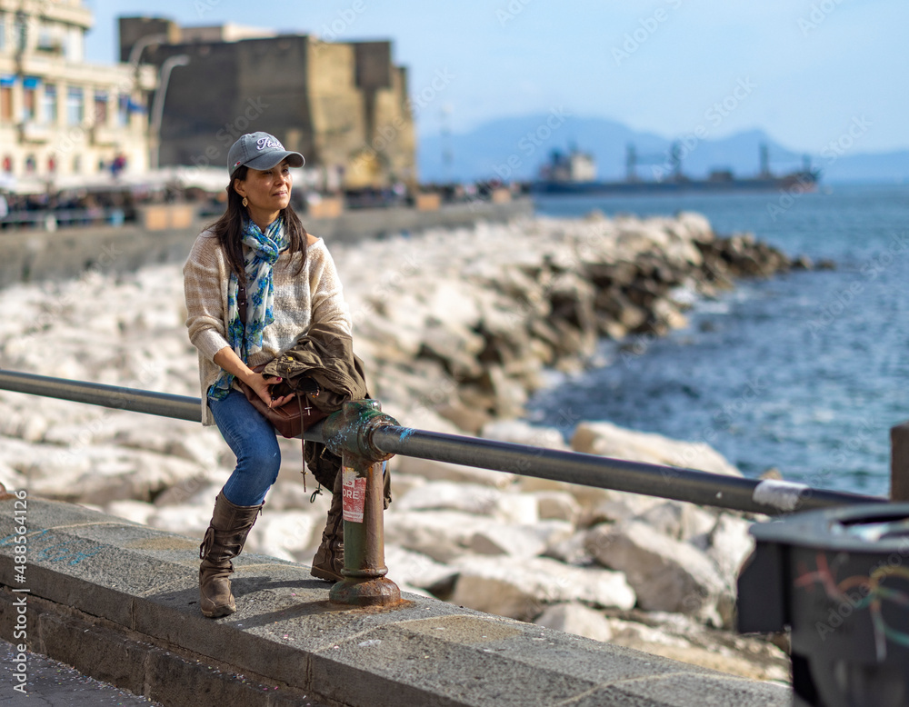 Naklejka premium woman sitting by the bay with a castle in the background