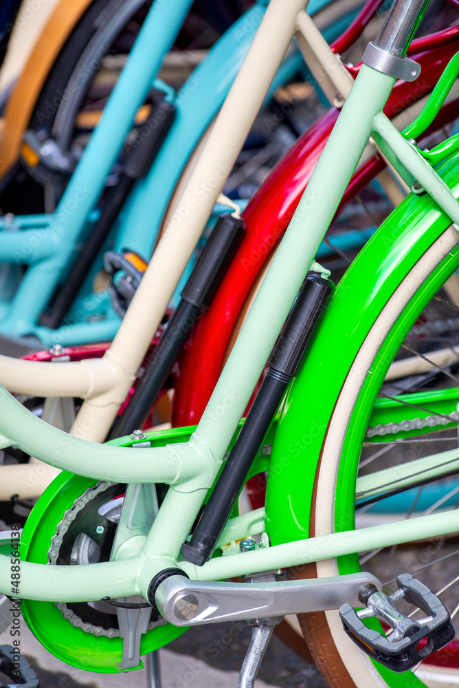 Colorful bicycles or bikes parked in the summer park outdoors, wheel closeup.