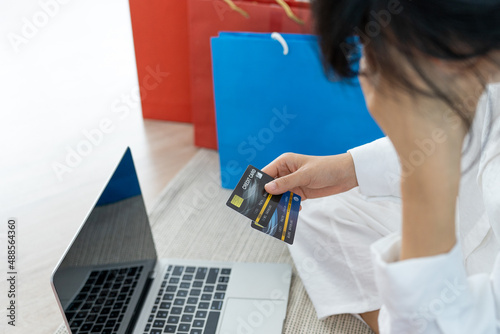 Stressed woman holding a credit card after shopping. No money to pay off credit card debt.