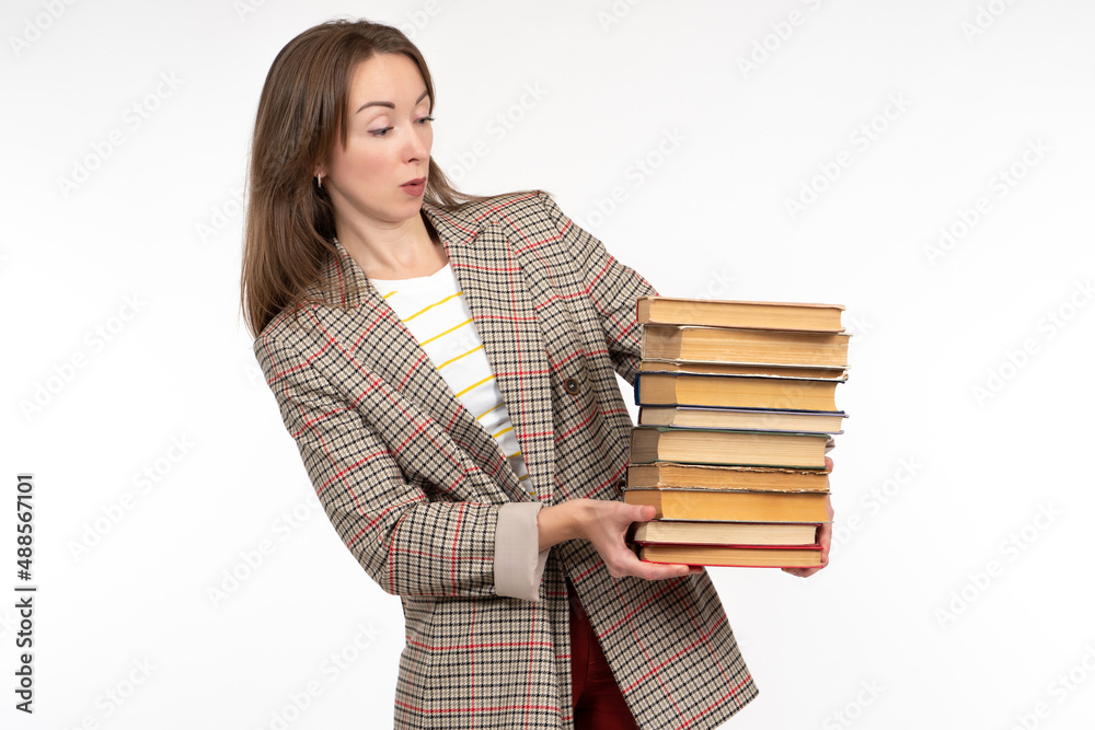 Book woman. Surprised girl with textbooks. Adult woman is looking at book. Adult female student with stack of books. Girl in jacket on white. Complicated self-education. Self-learning metaphor. Book woman. Surprised girl with textbooks. Adult woman is looking at book. Adult female student with stack of books. Girl in jacket on white. Complicated self-education. Self-learning metaphor.