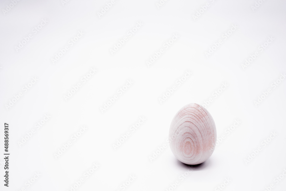 One unpainted hand-made wooden egg on a white background. Copy space One unpainted hand-made wooden egg on a white background. Copy space