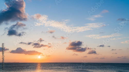 Sunset sky over sea in the evening with orange sunlight clouds