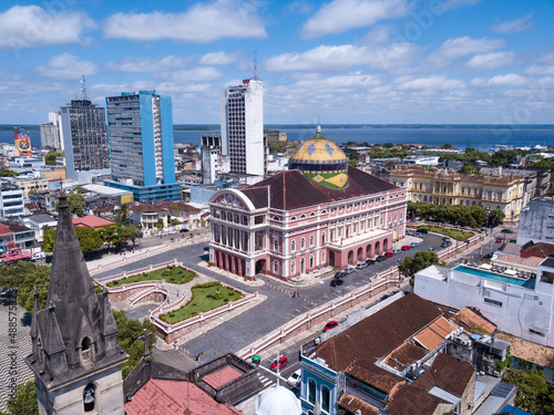 Beautiful drone aerial view of iconic Amazonas theater and city center houses, buildings and streets in sunny summer day in Amazon Rainforest. Rio Negro in the background. Manaus, Amazonas, Brazil. photo