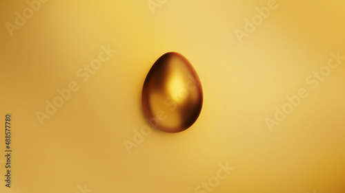 Photography Golden easter egg on gold foil background from above