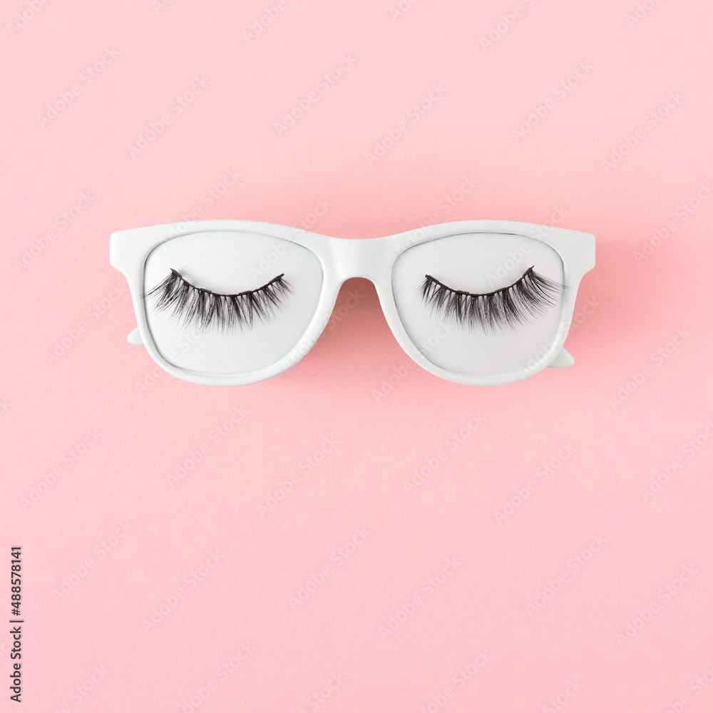 White tinted sunglasses and lashes on pastel pink background, flat lay. Minimal summer concept. White tinted sunglasses and lashes on pastel pink background, flat lay. Minimal summer concept.