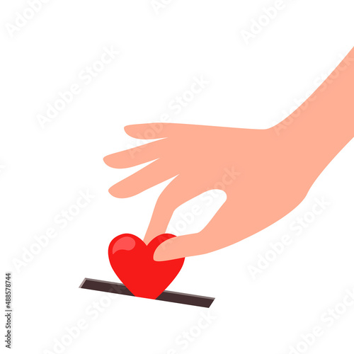 a person's hand puts a heart in a donation box. the concept of kindness, generosity, love, donation.