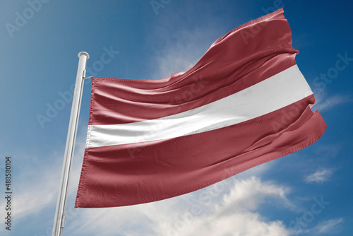 Latvia Flag is Waving Against Blue Sky