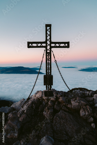 Obraz na płótnie Summit cross on mountain peak above sea of clouds at dusk w salonie