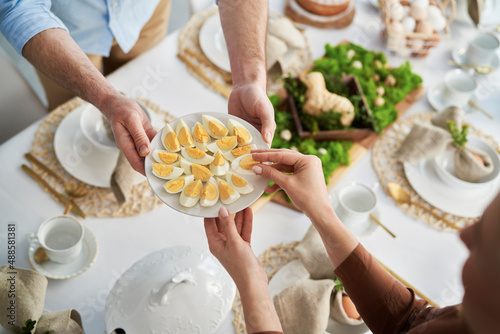 Canvas Print Top view of unrecognizable people sharing with egg during easter dinner