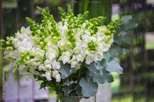 White vase with flowers in a restaurant. Basket with flowers, kibana, wedding floristry. photo