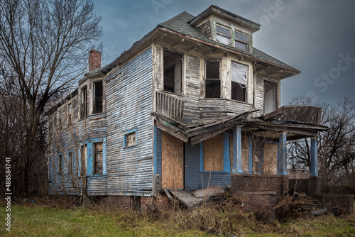 Crumbling and abandoned home with overcast sky