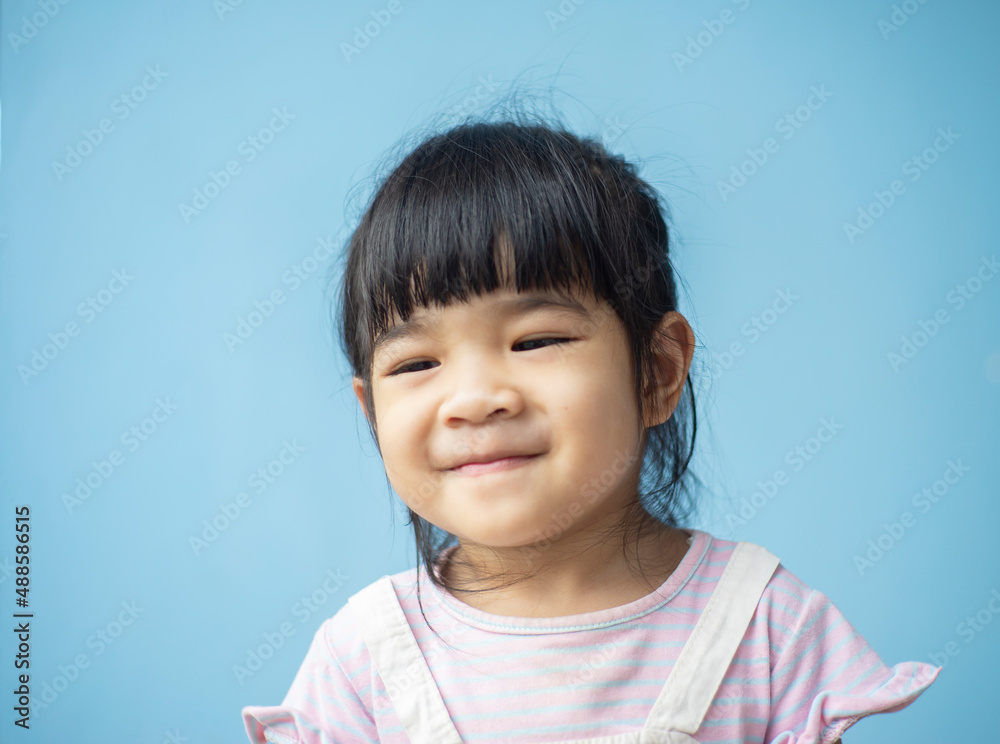 A headshot portrait of a cheerful baby Asian woman, a cute toddler little girl with adorable bangs hair, a child wearing a purple sweater smiling and don't looking to the camera.