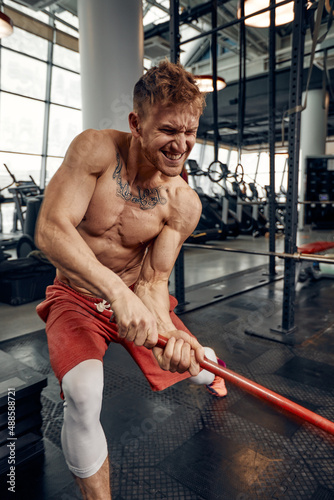 Canvas-taulu Man fitness training with large and heavy tire hits hammer