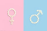 Signo femenino y masculino hecho con pastillas pildoras sobre un fondo de color rosa y celeste liso y aislado Vista superior. Copy space