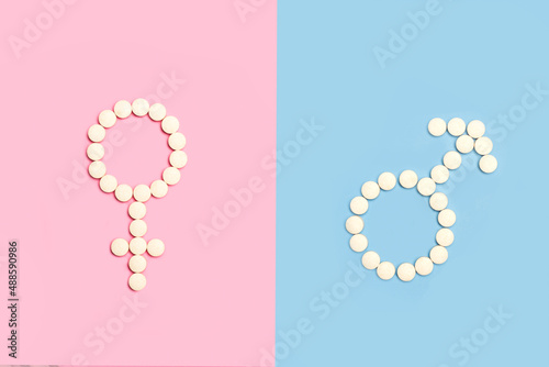 Signo femenino y masculino hecho con pastillas pildoras sobre un fondo de color rosa y celeste liso y aislado Vista superior. Copy space