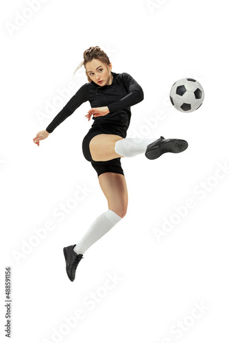 Attacking player. One sportive girl, female soccer player training with football ball isolated on white studio background. Sport, action, motion, fitness © master1305