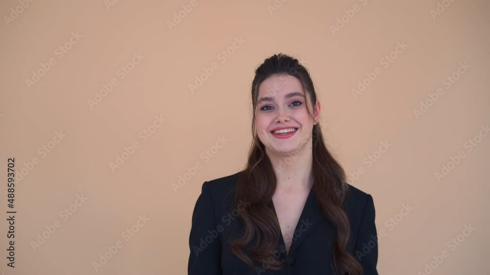 Shy young business woman showing winner gesture laughs and smile looking camera standing studio pastel color background. Beautiful female business person win little jackpot in lottery Shy young business woman showing winner gesture laughs and smile looking camera standing studio pastel color background. Beautiful female business person win little jackpot in lottery