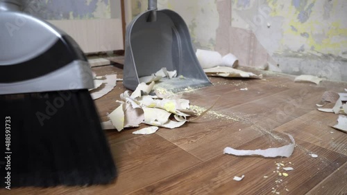 Clean up after repairs. Sweep up construction debris with a brush in a dustpan. Sweeping at home. Tools for cleaning the house. Make home repairs. The dust and debris after the renovation.