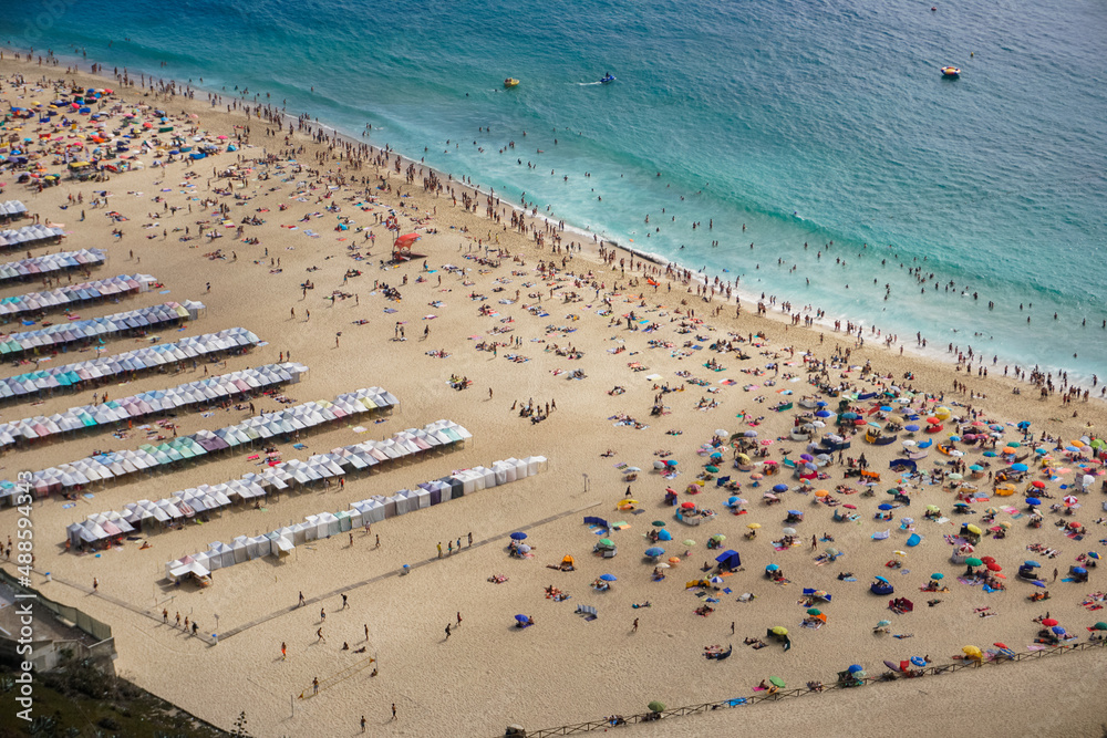 many people at the sunny full beach during summer. view from above. blue ocean. summer holidays in europe. many people at the sunny full beach during summer. view from above. blue ocean. summer holidays in europe.