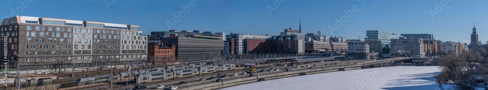 Panorama,  railway, central station, turn points, catenary, electric poles and tunnels. Train, office, station, hotel buildings. Icy canal Karlbergskanalen, in Stockholm