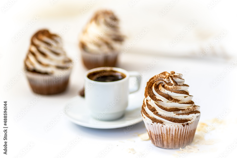 Black coffee with cupcakes and muffins. Spice cupcakes with creamcheese frosting decorated with a cocoa Black coffee with cupcakes and muffins. Spice cupcakes with creamcheese frosting decorated with a cocoa