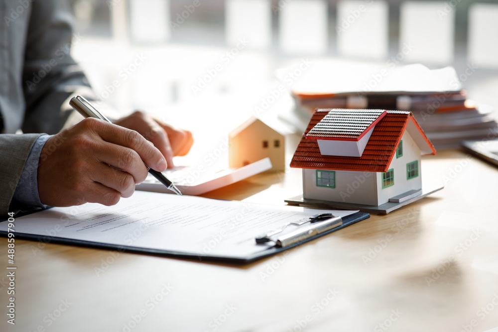 Fototapeta premium Close up house model mortgage loan with businessman real estate broker signs a purchase contract or mortgage for a Home Interiors, real property estate concept.