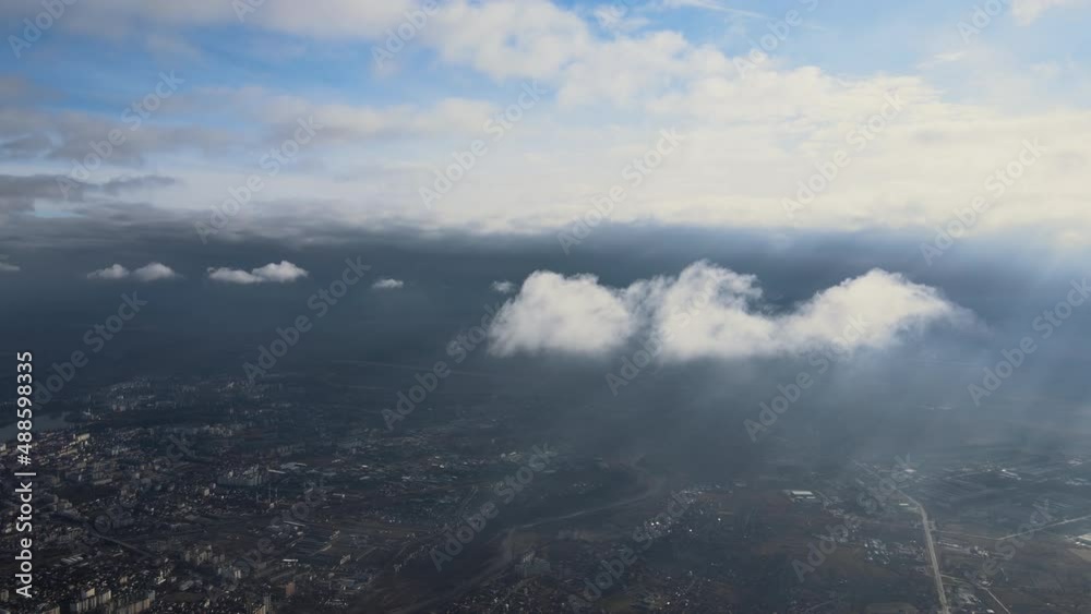 Aerial view from high altitude of distant city covered with puffy cumulus clouds forming before rainstorm. Airplane point of view of cloudy landscape Aerial view from high altitude of distant city covered with puffy cumulus clouds forming before rainstorm. Airplane point of view of cloudy landscape