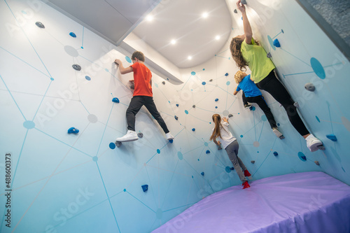 Girls and boys climbing up practice wall