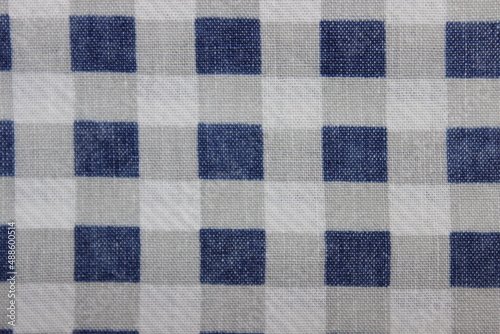 Stripes and squares on the surface of the old fabric. Macro.
