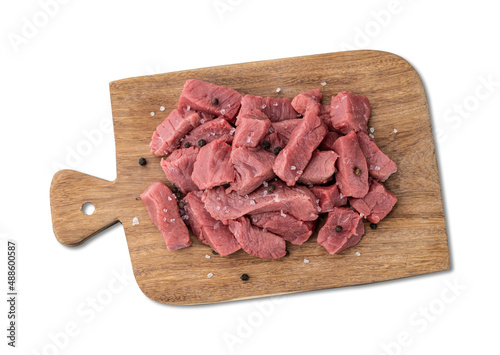 Chopped topside meat over wooden board with seasonings isolated over white background photo